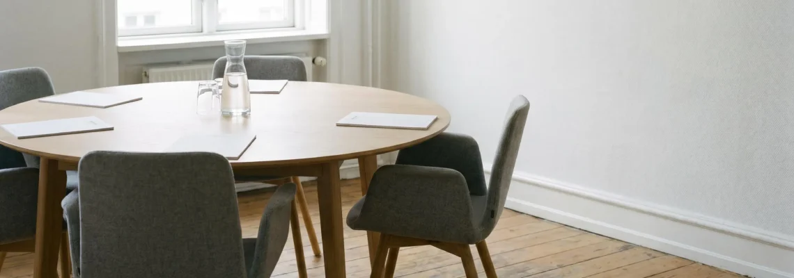 Salle de réunion sobre avec table ronde, symbolisant le dialogue social.